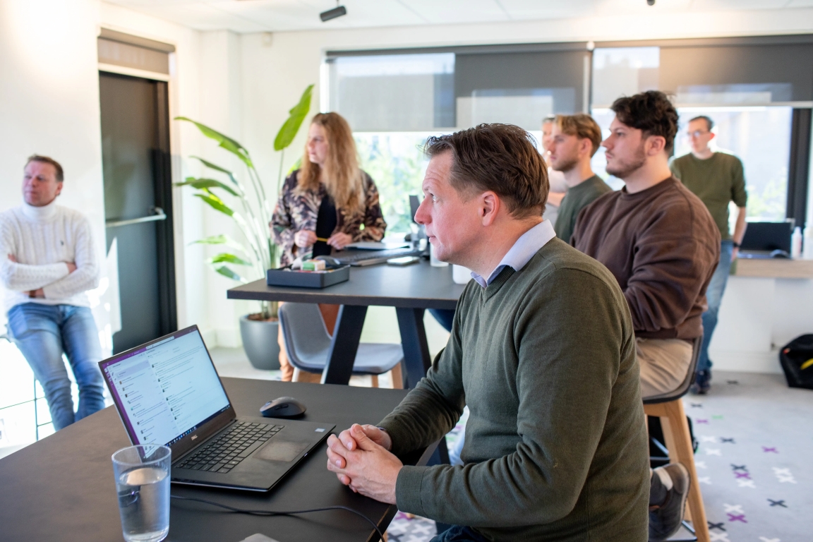Specialisten van Florisoft in een sessie luisterend naar de wensen van de klant, waarbij alles geregistreerd wordt op een laptop onder het genot van een bak koffie of een glaasje water.